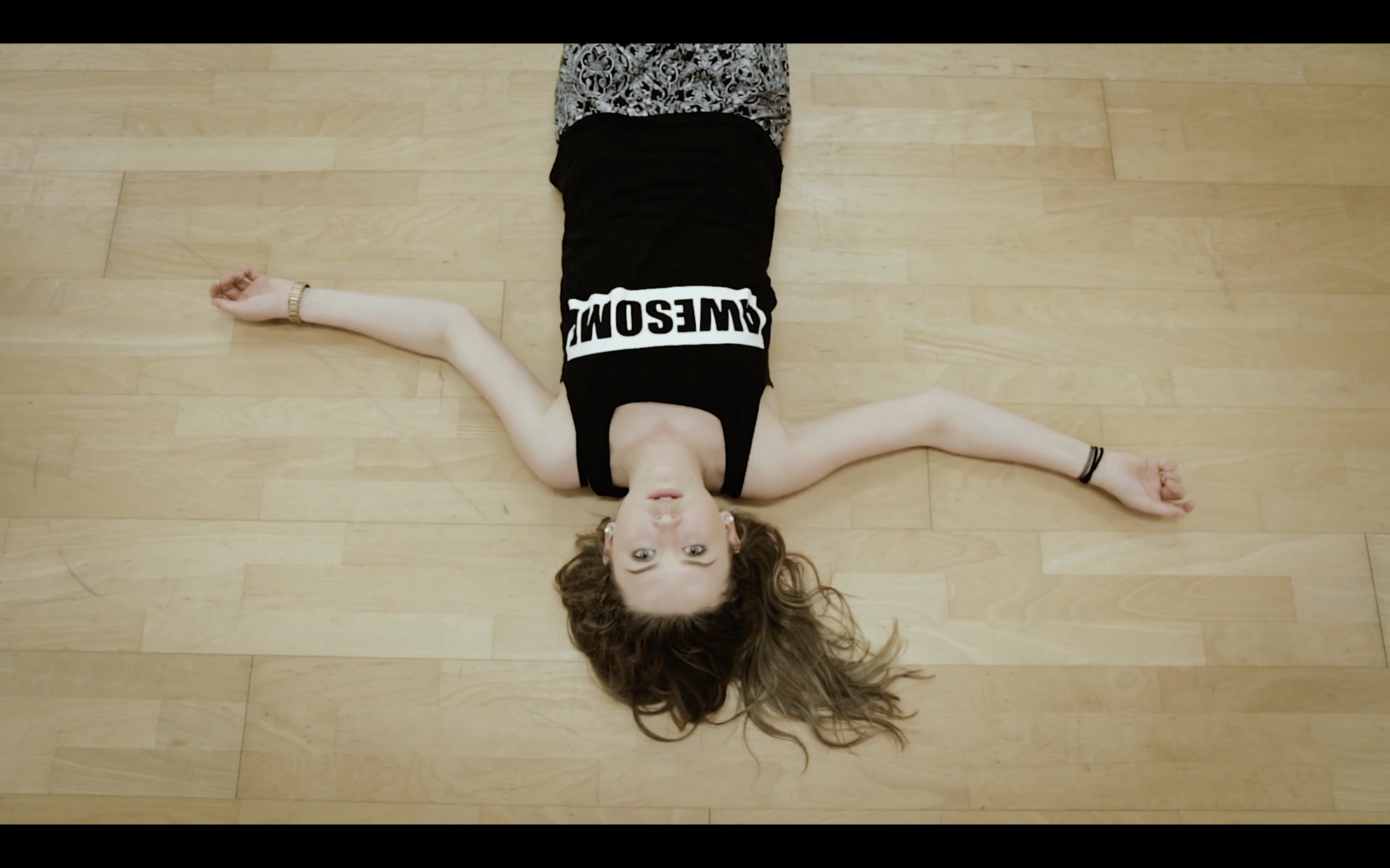 Girl laid on a floor looking up at the camera