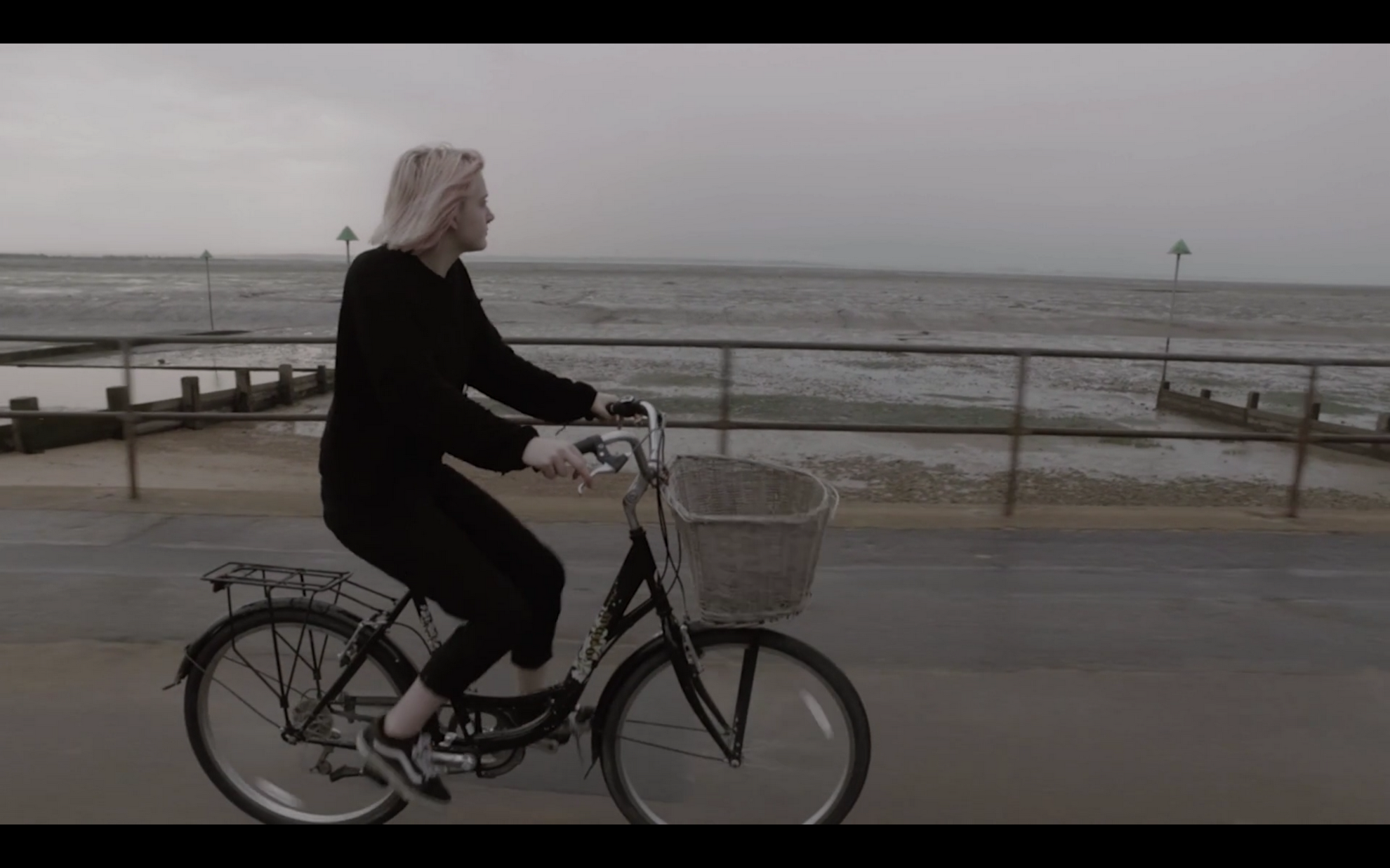 Girl riding a bike along a promenade