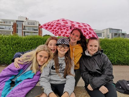 girls smiling at camera in the rain