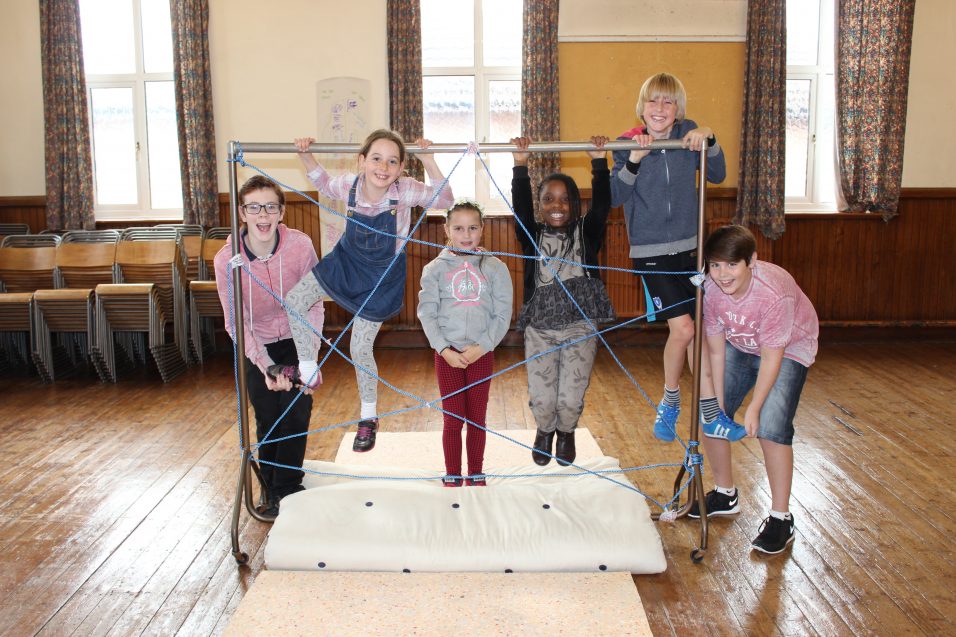 children and young people playing and climbing on frame