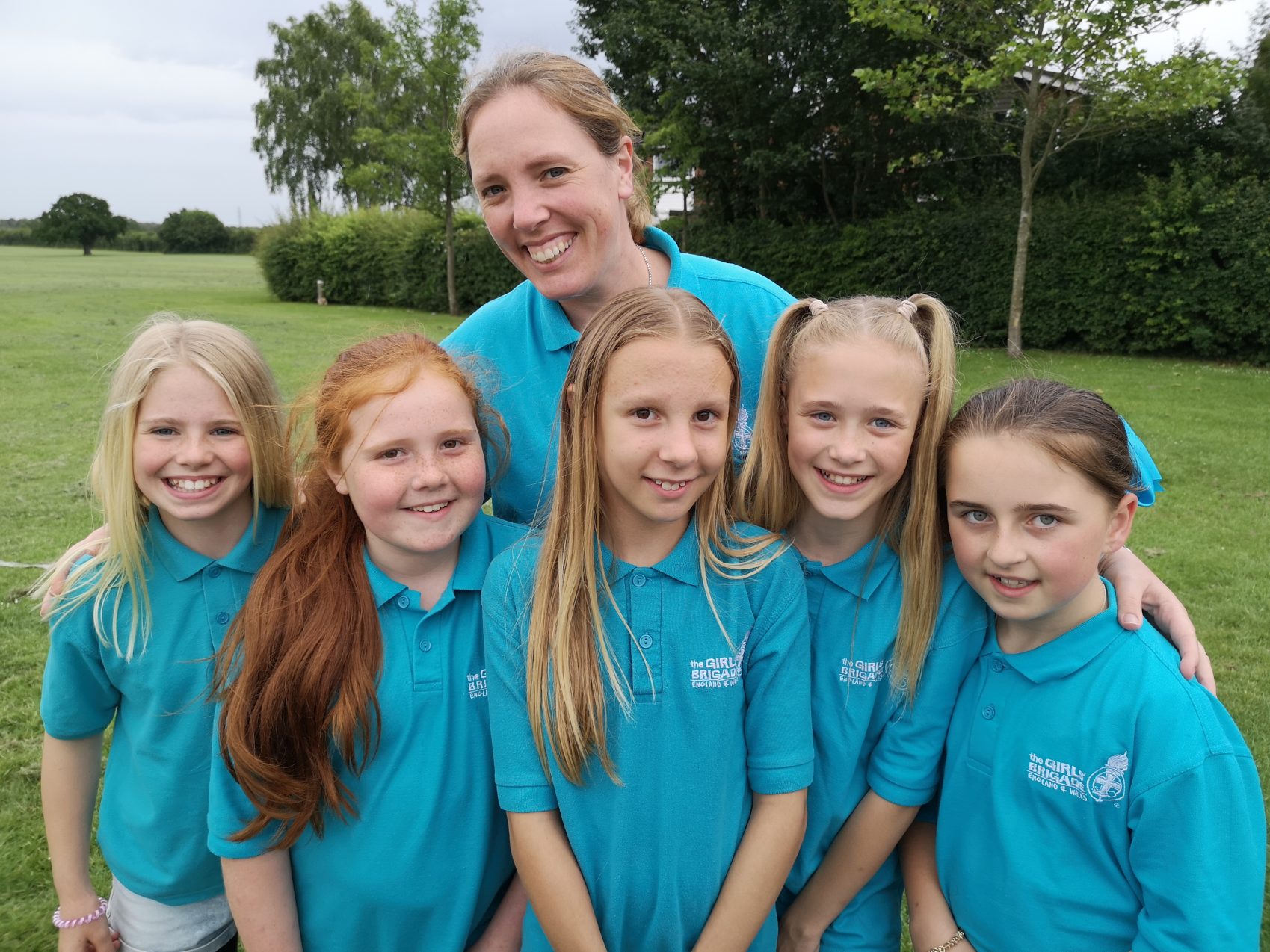 Girls' Brigade volunteer with arms around n:gage girls