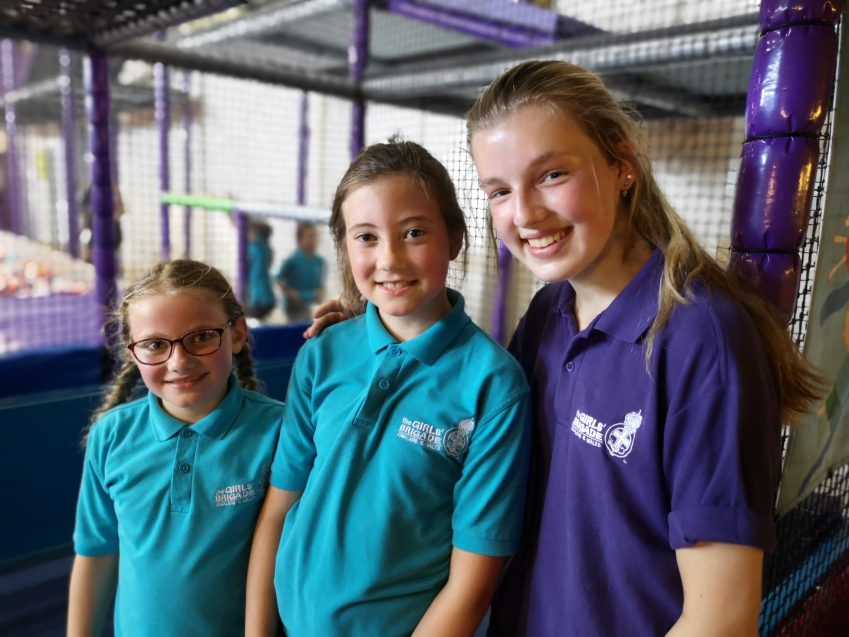 Two n:gage girls and one n:spire girl smiling at camera in soft play area