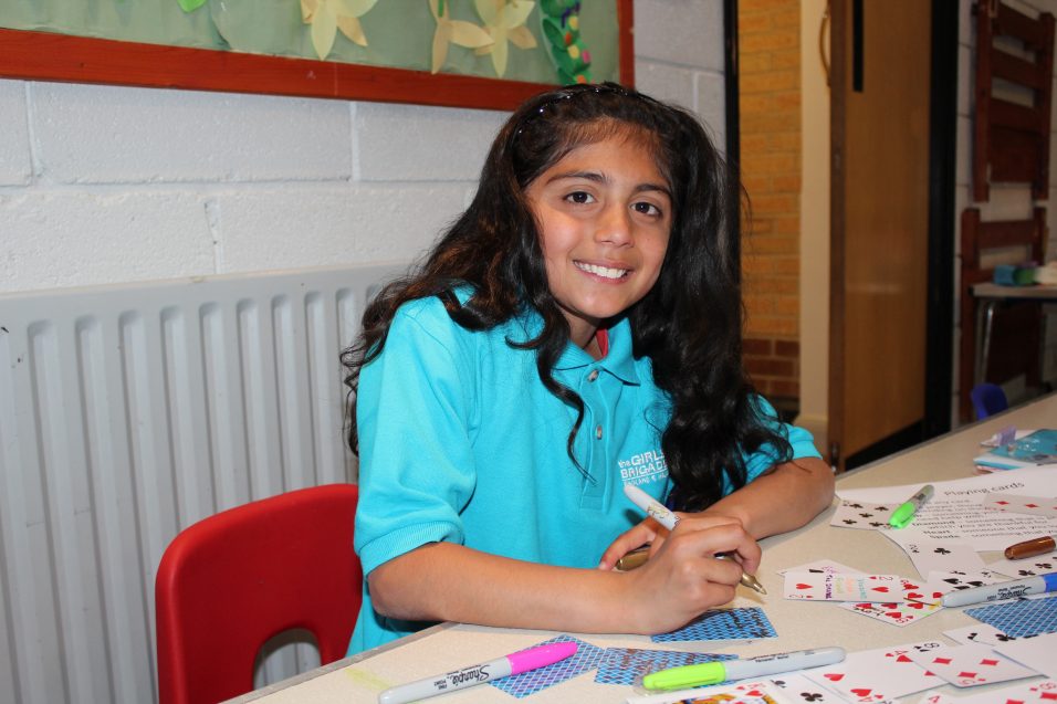 n:gage girl decorating playing cards smiling at camera