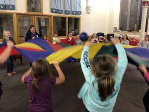 girls and volunteers playing with a parachute at 1st Ryton