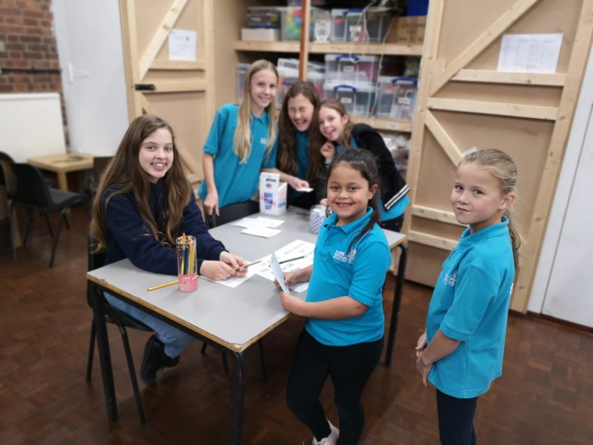 six n:gage girls laughing and smiling around table on UK parliament week