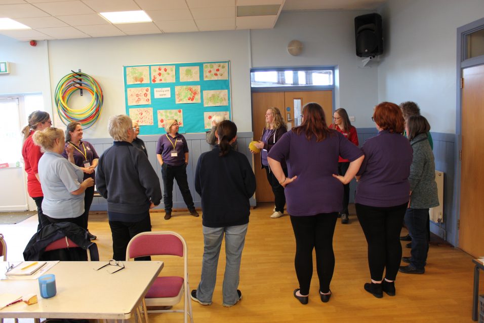 Girls' Brigade volunteers stood in circle with ball for training activity