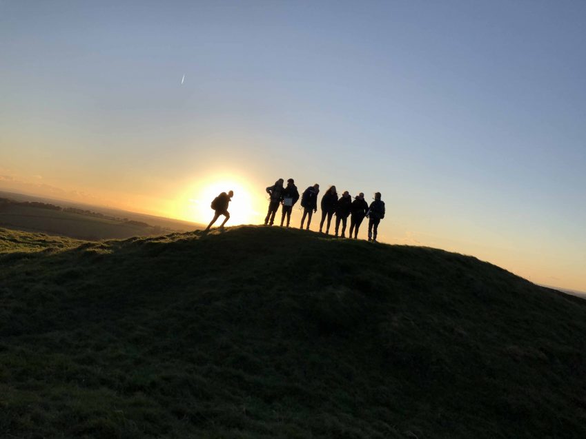 hikers in front of sunset