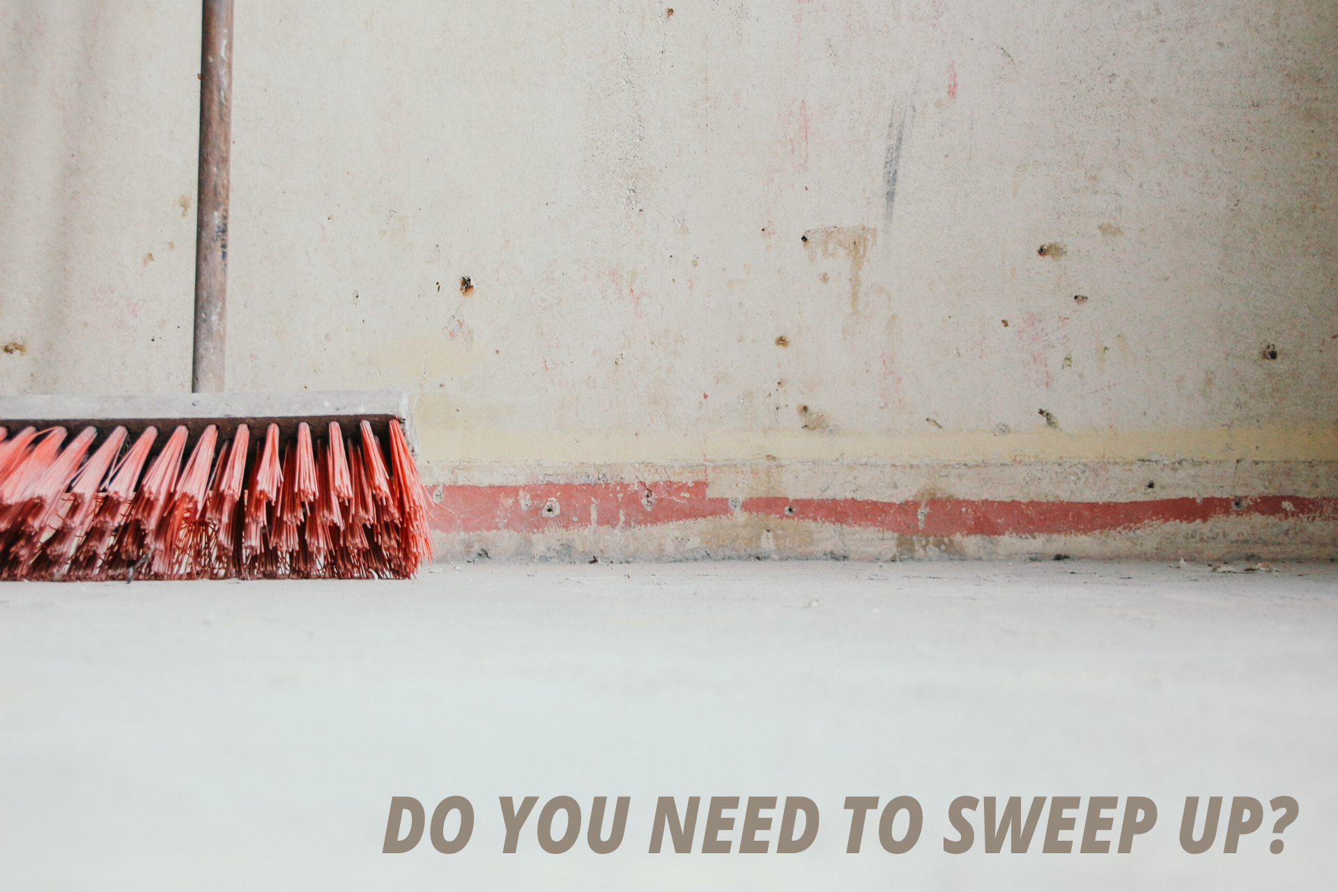 Sweeping brush head propped against a wall