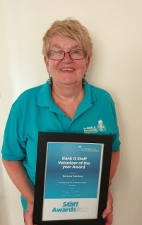 GB volunteer Barbara holding Bank It Volunteer of the year award