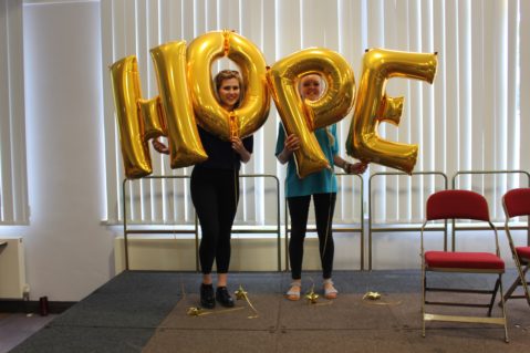 Two leaders holding HOPE balloons