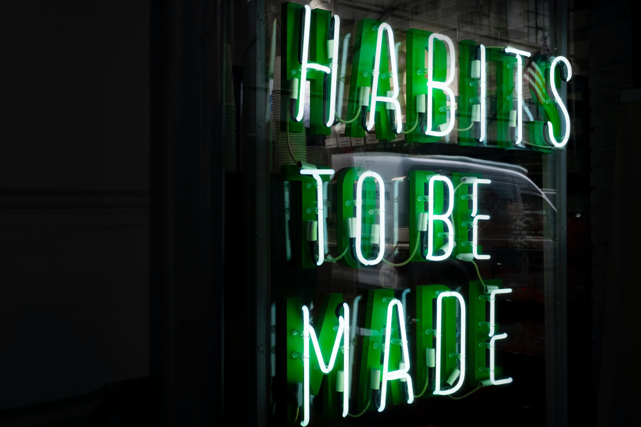 The words 'habits to be made' in neon lights