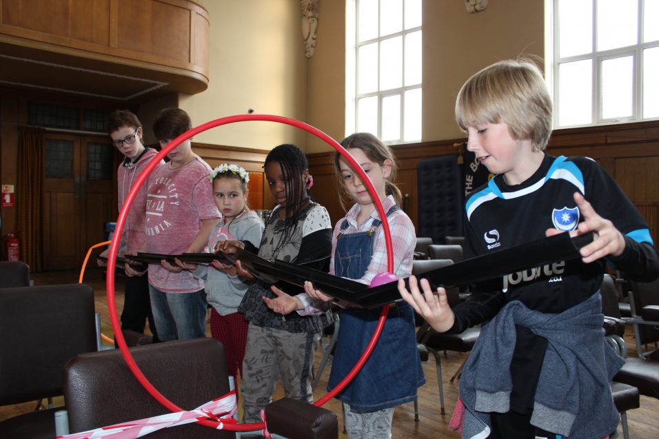 Six young people playing problem solving game