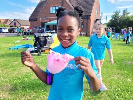 n:gage member eating candyfloss in busy church garden