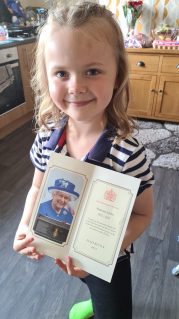 Darcey holding card from the Queen