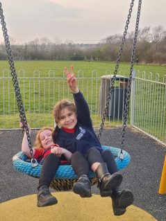 n:vestigate members playing in large park swing