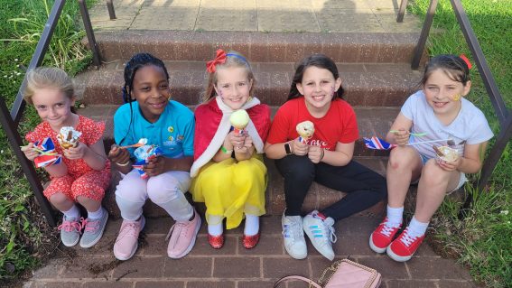 GB members sat on steps eating ice creams in Jubilee outfits