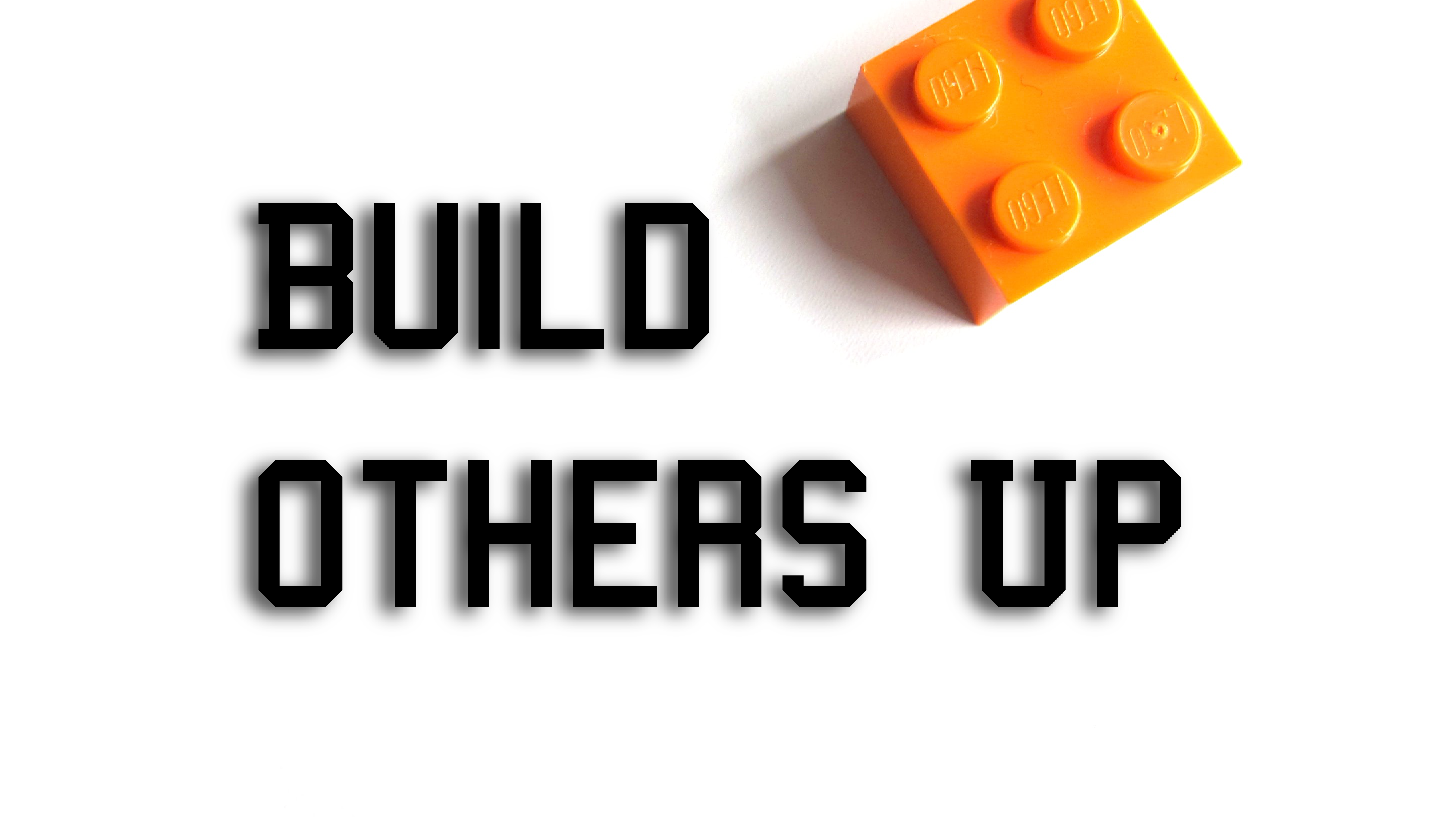 Single lego block on white background with words 'build others up'