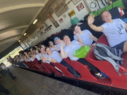 GB members waving from rollercoaster train