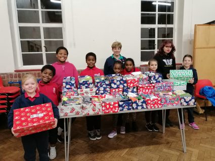 GB members around a table of filled shoeboxes