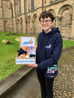 n:spire member holding box of GB items outside Durham Cathedral
