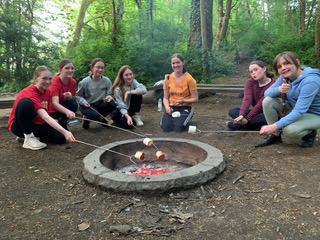 GB members toasting marshmallows around a campfire