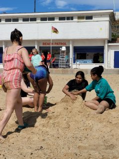 GB members playing in sand on beach