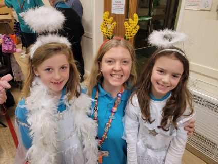 Two GB members dressedas angels with GB leader wearing reindeer antlers