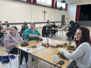 GB leaders gathered around a table making crafts