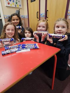 Five GB members holding up tubes of Smarties