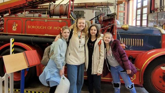 GB leader Grace with arms around GB members stood in front of vintage fire engine