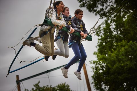Three girls on swing.