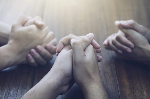 Hands clasped in prayer.